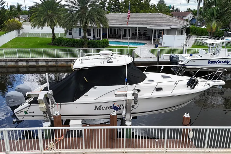Slide: The Image of 2007 Pursuit OS 335 Offshore boat docked near a waterfront home with palm trees. - 5