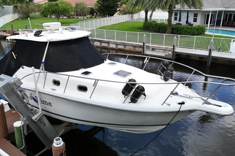 Slide: The Image of 2007 Pursuit OS 335 Offshore boat docked near a poolside patio. - 6