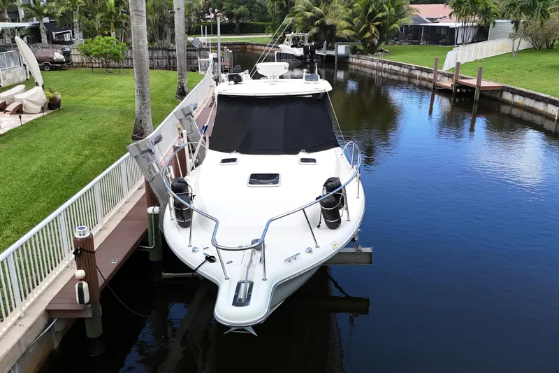 Slide: The Image of 2007 Pursuit OS 335 Offshore boat docked in a serene canal setting. - 7