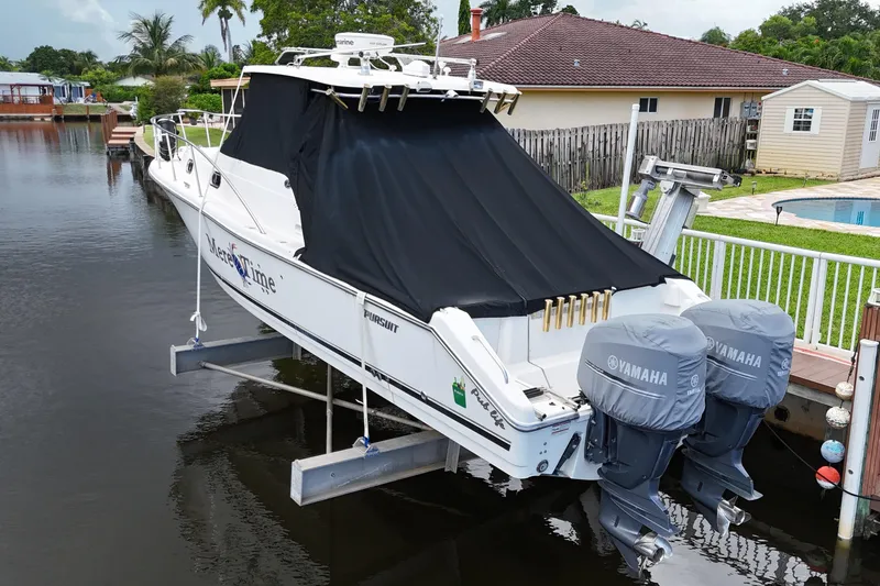 Slide: The Image of 2007 Pursuit OS 335 Offshore boat docked near a waterfront home with palm trees. - 8