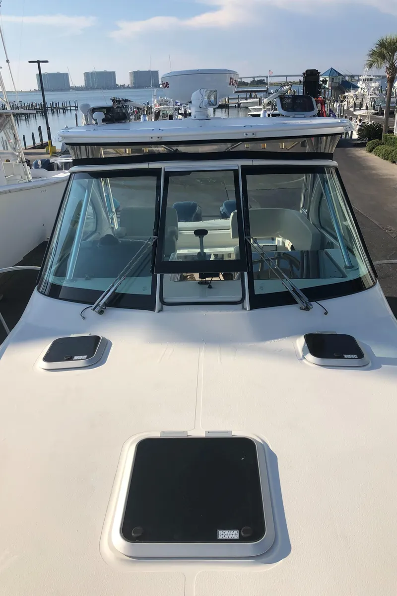 Slide: The Image of 2007 Pursuit OS 335 Offshore boat docked near waterfront home. - 9