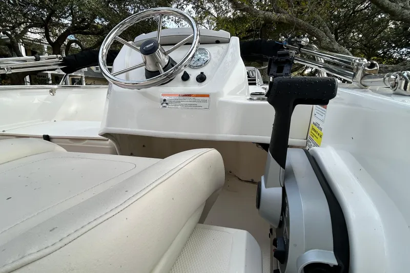 Slide: The Image of 2023 Boston Whaler 160 Super Sport boat interior with steering wheel and controls. - 16