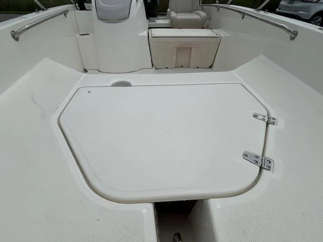 Slide: The Image of 2023 Boston Whaler 160 Super Sport boat on trailer, parked near a road with trees. - 4