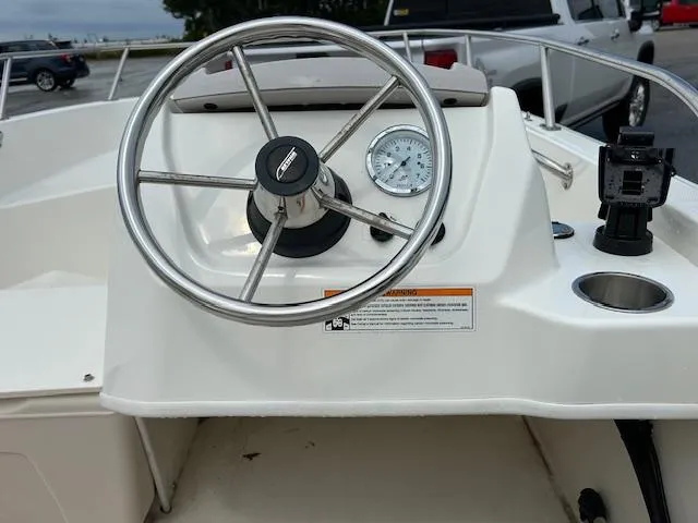 Slide: The Image of 2023 Boston Whaler 160 Super Sport boat interior with steering wheel and controls. - 8