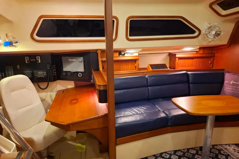 Slide: The Image of Interior of 2003 Island Packet 485 yacht with blue seating and wooden table. - 11