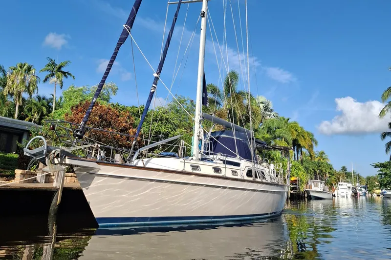 Slide: The Image of Island Packet 485 sailboat from 2003 docked in a tropical canal setting. - 2