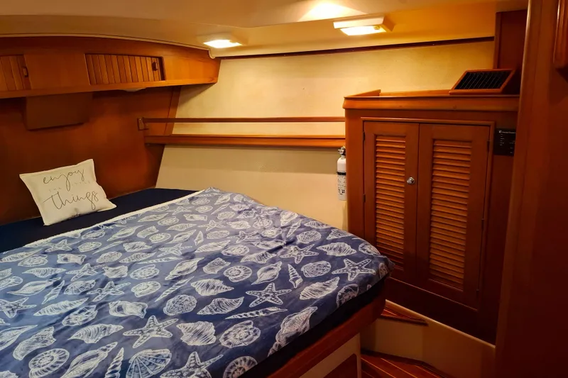 Slide: The Image of Cozy cabin interior of 2003 Island Packet 485 sailboat with nautical-themed bedding. - 24