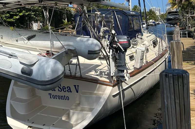 Slide: The Image of Island Packet 485 sailboat docked, featuring a Yamaha motor and inflatable dinghy. - 3