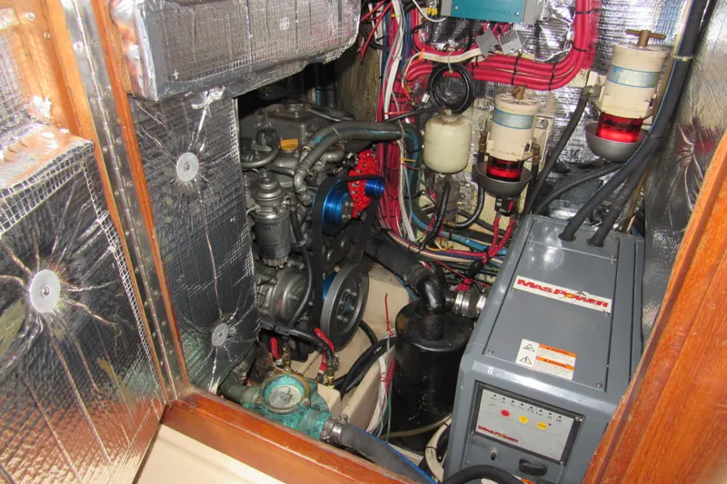 Slide: The Image of Engine room of 2003 Island Packet 485 sailboat, featuring mechanical components and wiring. - 34