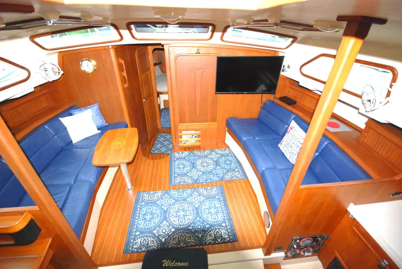 Slide: The Image of Luxurious 2003 Island Packet 485 yacht interior with blue seating and wooden finishes. - 7