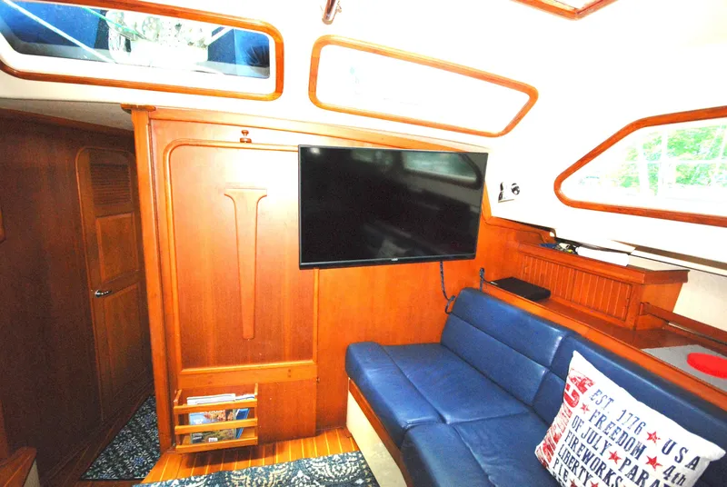 Slide: The Image of Interior of 2003 Island Packet 485 yacht with blue seating and mounted TV. - 8