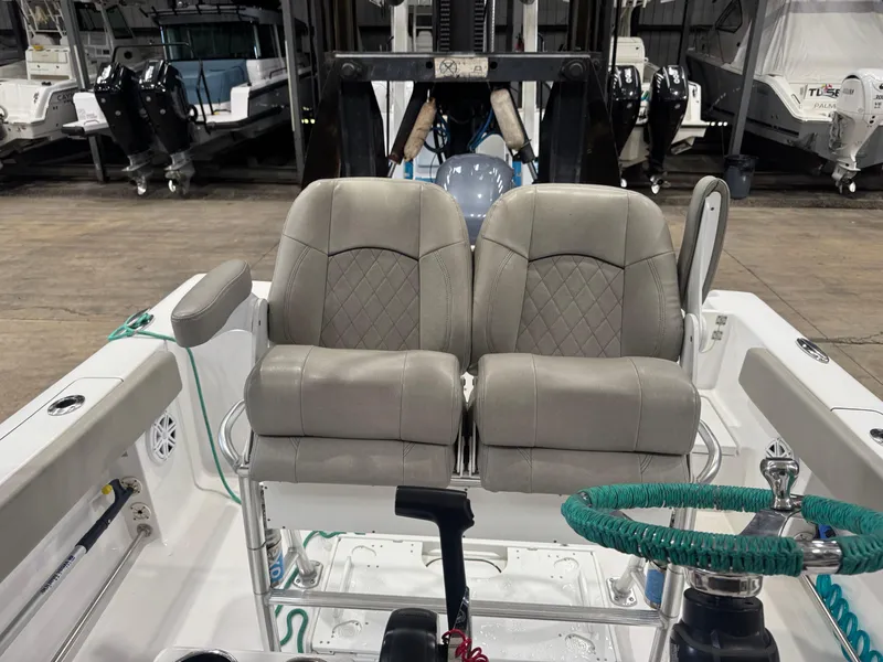 Slide: The Image of 2023 Sportsman 212 boat interior with dual cushioned seats and green-wrapped steering wheel. - 7