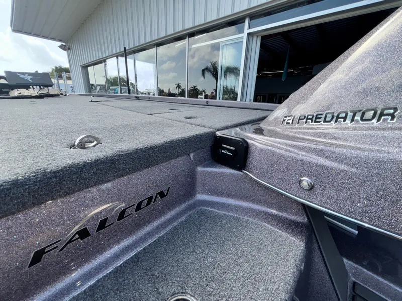 Slide: The Image of 2025 Falcon Boats 21 Predator dashboard with steering wheel and controls under clear blue sky. - 26