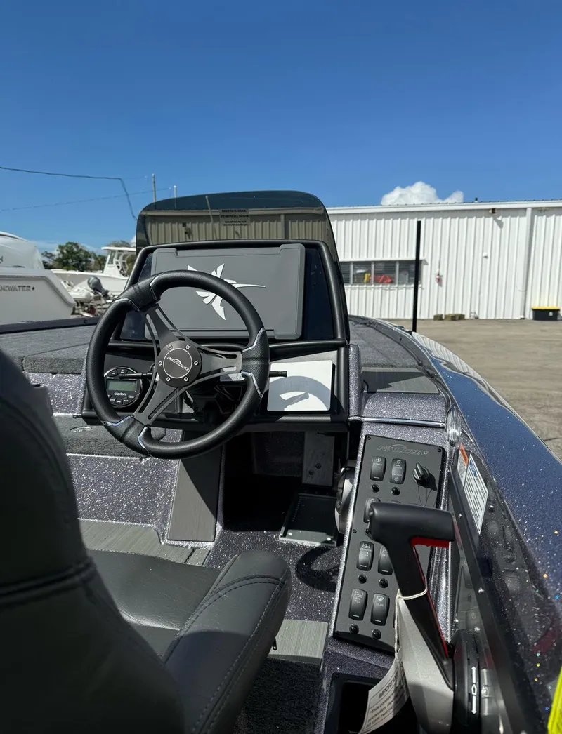 Slide: The Image of 2025 Falcon Boats 21 Predator dashboard with steering wheel and navigation display. - 27