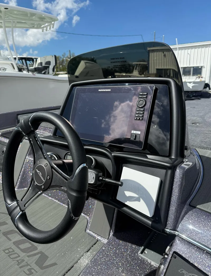 Slide: The Image of Control panel of 2025 Falcon Boats 21 Predator with various switches and key ignition. - 28