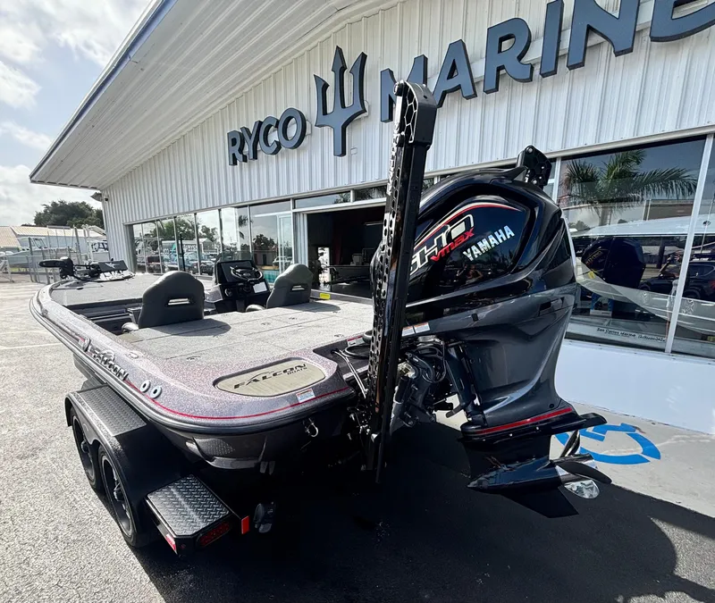 Slide: The Image of 2025 Falcon Boats 21 Predator dashboard and seating area in a parking lot. - 9