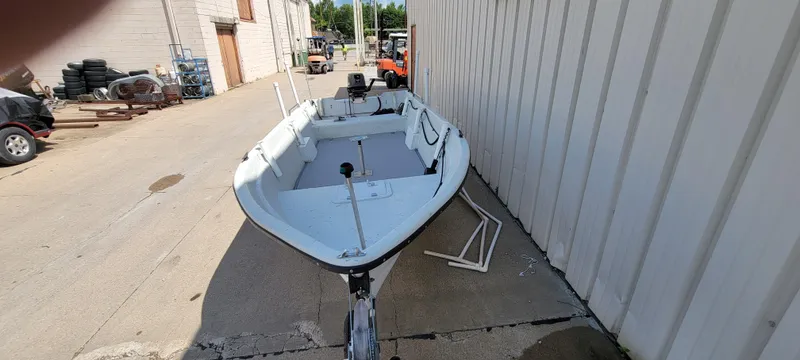 Slide: The Image of 1996 Tracker Pro Angler V 16 boat parked beside a building on a sunny day. - 13