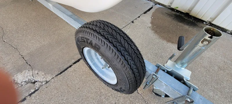 Slide: The Image of Trailer wheel of a 1996 Tracker Pro Angler V 16 on concrete surface. - 14