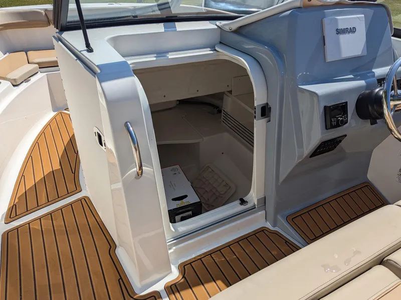 Slide: The Image of 2026 Bayliner Trophy T22SC boat interior with open storage compartment and teak flooring. - 10