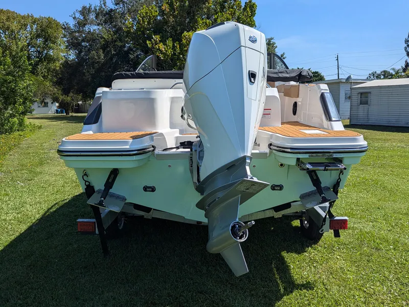 Slide: The Image of 2026 Bayliner Trophy T22SC boat with outboard motor on grassy area. - 4