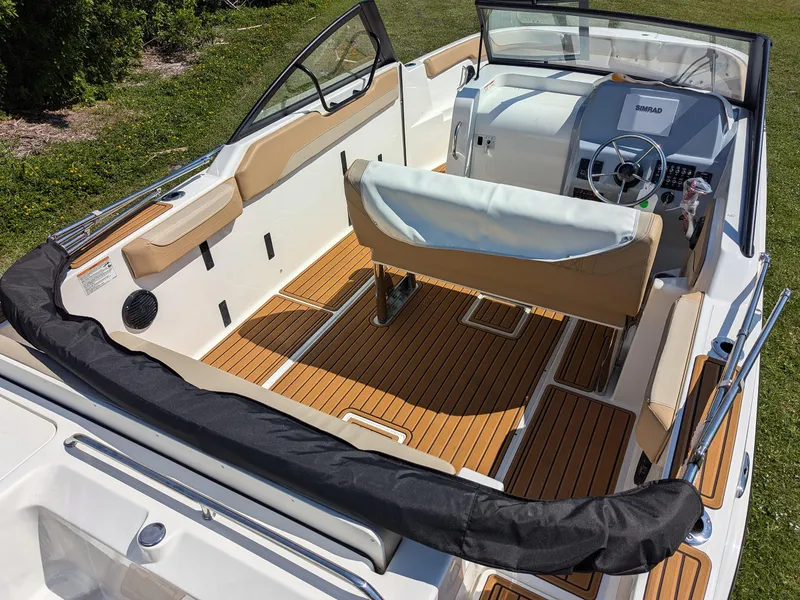 Slide: The Image of Interior view of 2026 Bayliner Trophy T22SC boat with tan seating and wood flooring. - 5