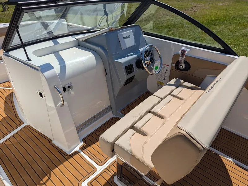 Slide: The Image of 2026 Bayliner Trophy T22SC boat interior with beige seating and modern dashboard. - 6