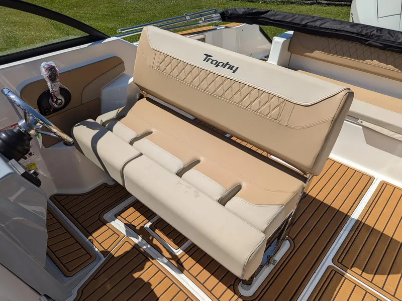 Slide: The Image of 2026 Bayliner Trophy T22SC boat interior with beige seating and wood-style flooring. - 8