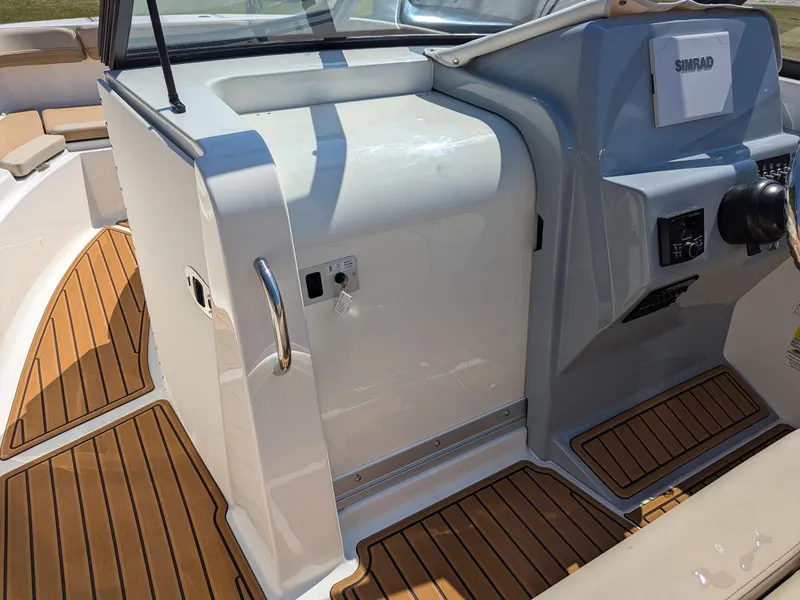Slide: The Image of 2026 Bayliner Trophy T22SC boat interior with wood flooring and control panel. - 9