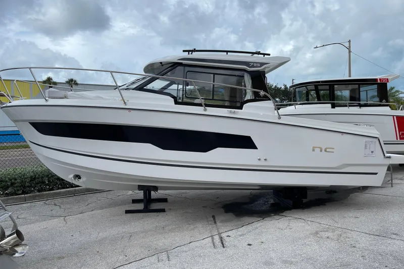 The Image of 2026 Jeanneau NC 795 boat displayed outdoors under clear blue sky. - 0