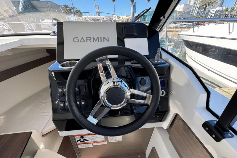 Slide: The Image of Steering wheel and Garmin display on 2026 Jeanneau NC 795 Weekender boat. - 13