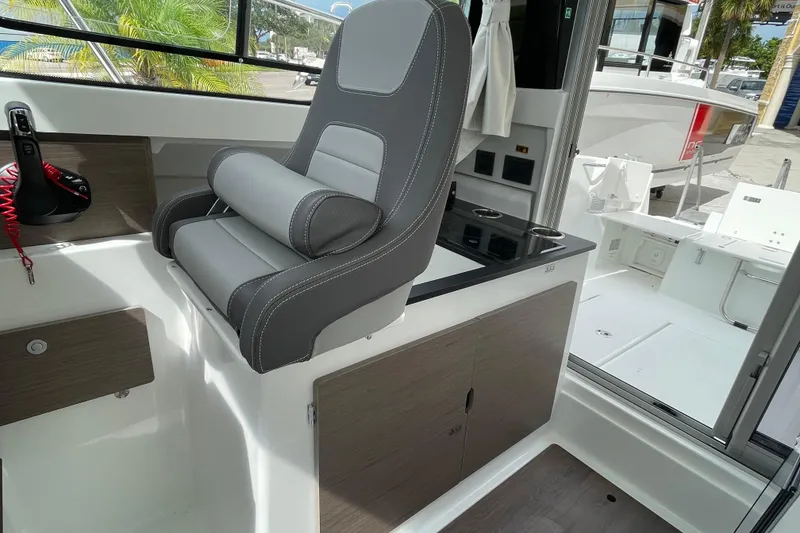 Slide: The Image of 2026 Jeanneau NC 795 Weekender boat interior with seating and table, dockside view. - 5