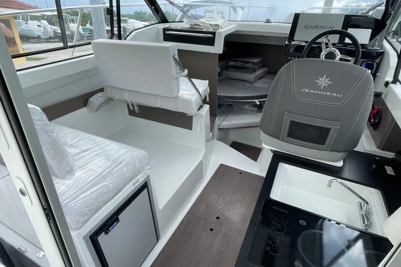 Slide: The Image of 2026 Jeanneau NC 795 Weekender interior with helm, sink, and stove. - 9