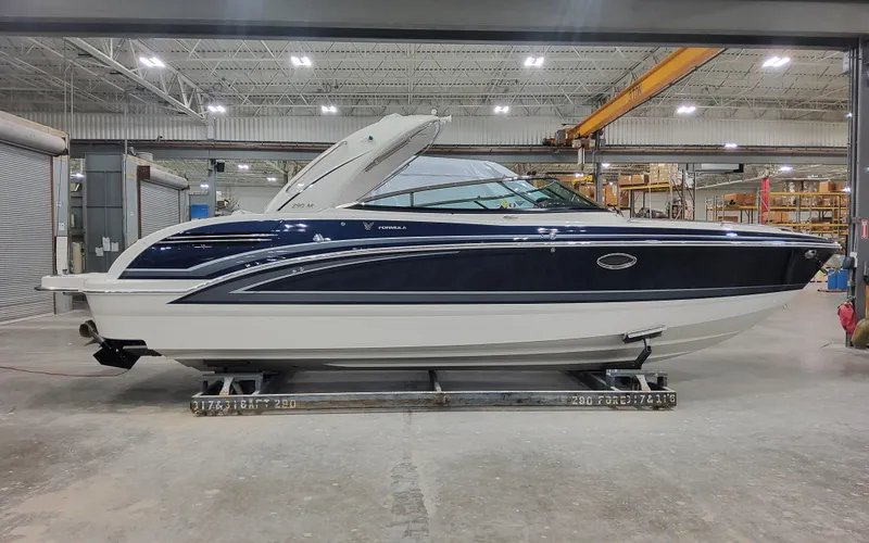 The Image of 2026 Formula 290 Bowrider boat in a warehouse setting, side view. - 0