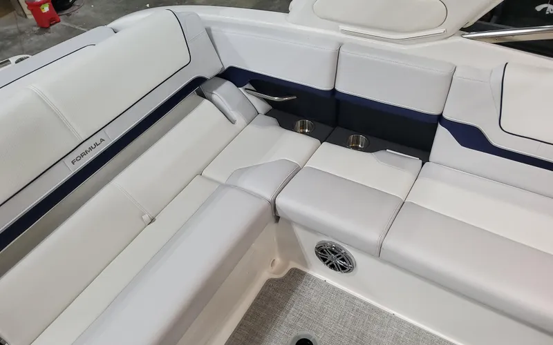Slide: The Image of 2026 Formula 290 Bowrider interior with white and navy seating, cup holders, and speaker. - 10