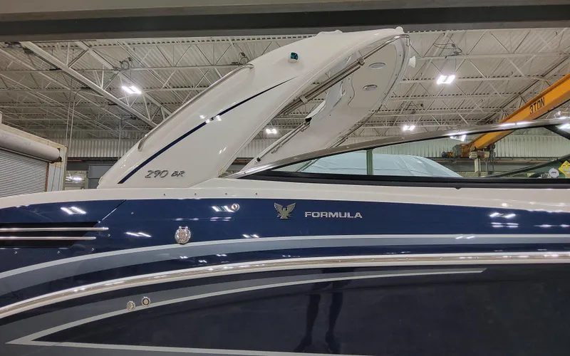 Slide: The Image of 2026 Formula 290 Bowrider boat in a showroom, featuring sleek blue and white design. - 5