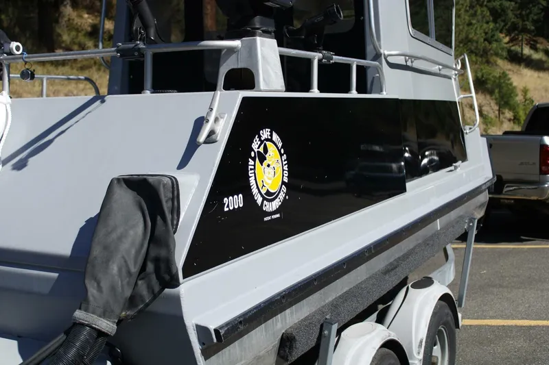 Slide: The Image of 2005 ACB 27 boat on trailer, featuring "Bee Safe" logo on side panel. - 19