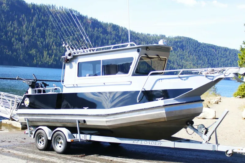 Slide: The Image of 2005 ACB 27 boat on trailer by scenic lake and forested hills. - 2