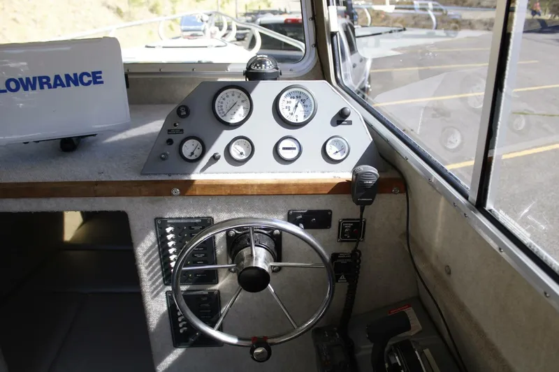 Slide: The Image of Steering console of a 2005 ACB 27 boat with gauges and controls. - 33