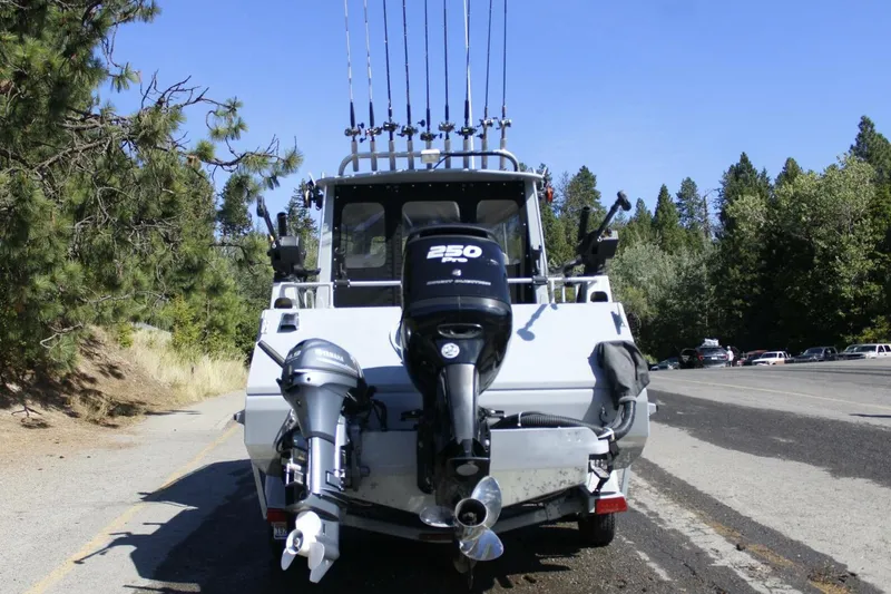 Slide: The Image of ```json { "alt_text": "Rear view of 2005 ACB 27 boat with outboard motors and fishing rods." } ``` - 4
