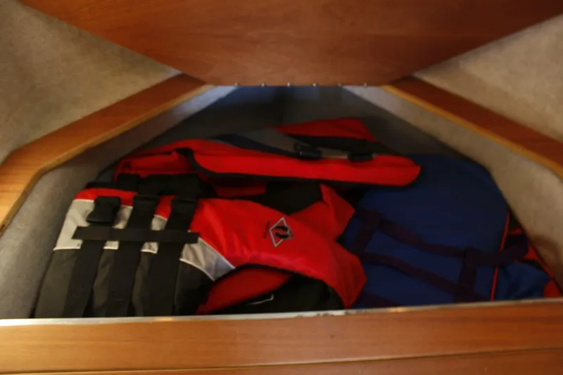 Slide: The Image of Life jackets stored in a wooden compartment on an ACB 27, 2005 model boat. - 43