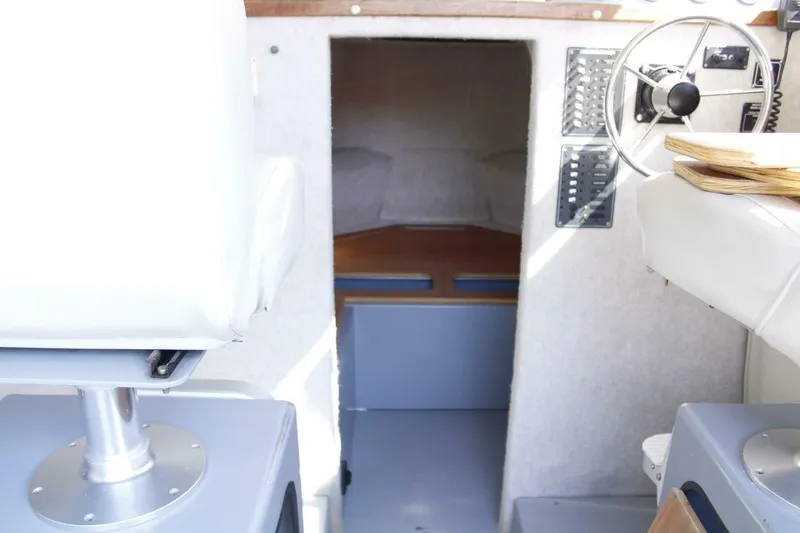 Slide: The Image of Interior of a 2005 ACB 27 boat showing steering wheel and cabin entrance. - 45
