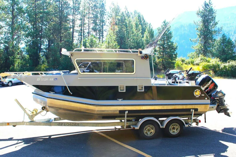 Slide: The Image of 2005 ACB 27 boat on trailer, parked in a scenic forested area. - 53