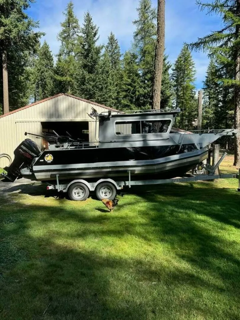 Slide: The Image of 2005 ACB 27 boat on trailer in forested yard, near a shed. - 56