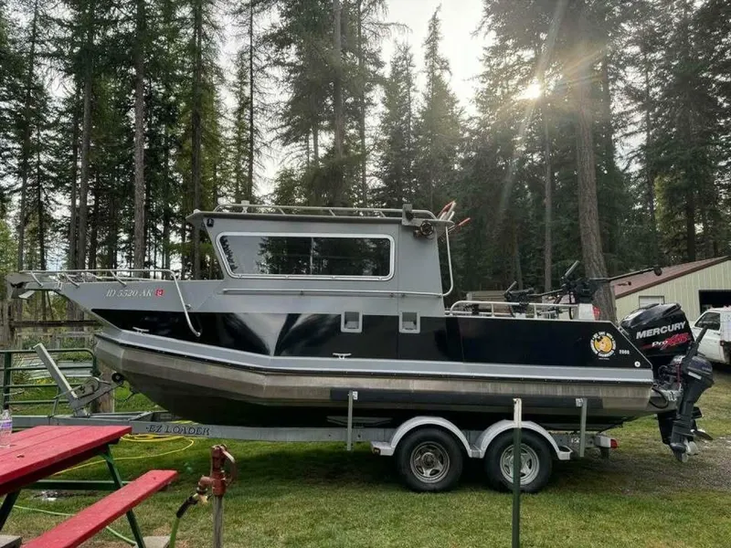Slide: The Image of 2005 ACB 27 boat on trailer in forested area with sunlight filtering through trees. - 59