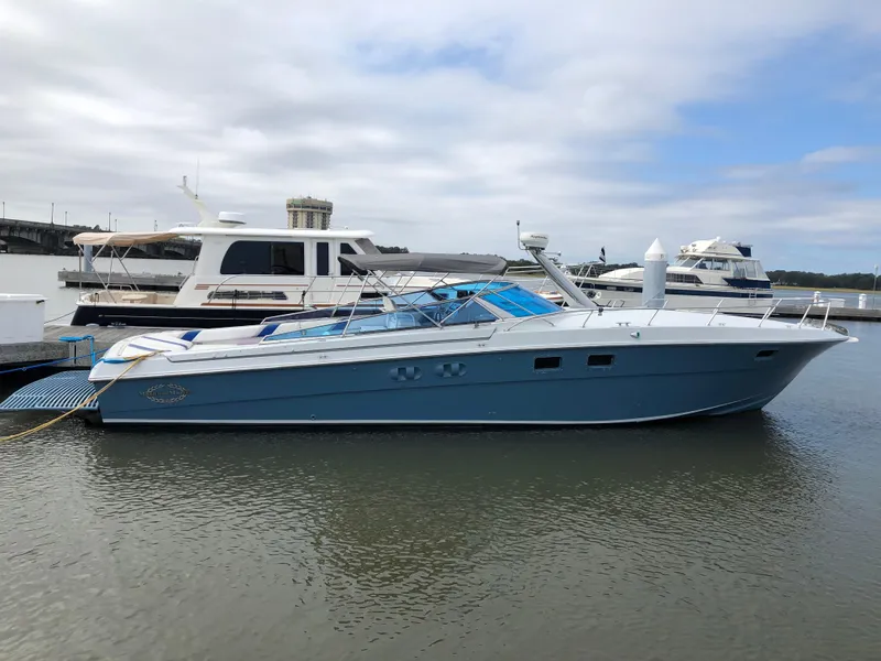 Slide: The Image of 1988 Magnum 40 Sport yacht docked in a marina, featuring sleek design and blue hull. - 1