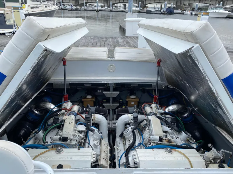 Slide: The Image of 1988 Magnum 40 Sport boat engine compartment with twin diesel engines at a marina. - 12