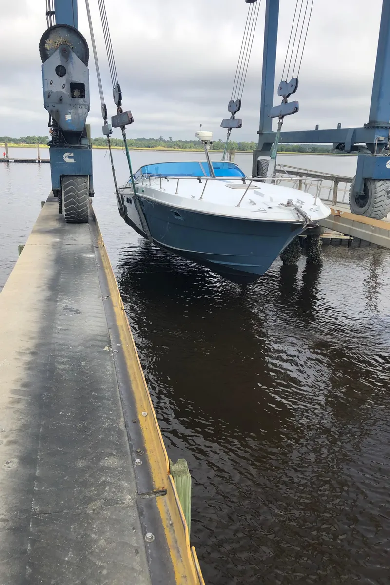 Slide: The Image of 1988 Magnum 40 Sport boat being lifted by a crane over water. - 15