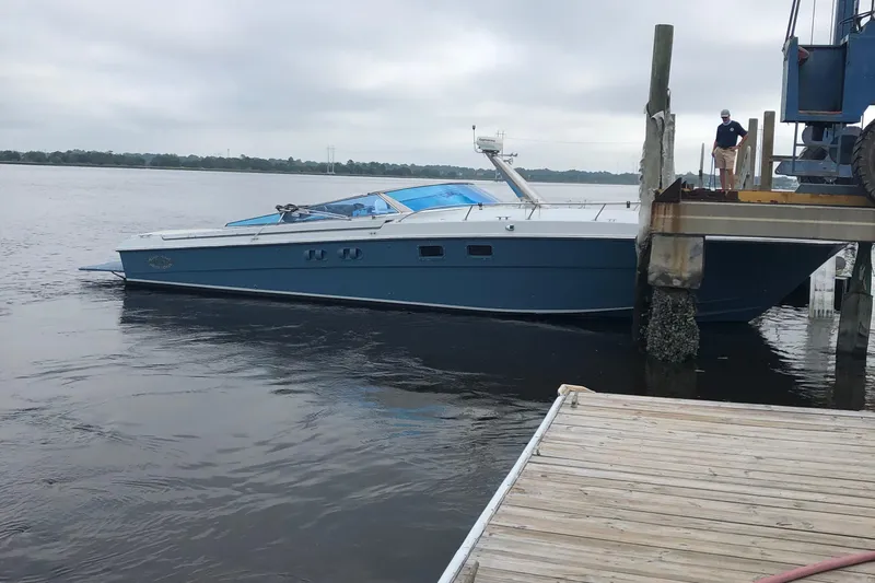 Slide: The Image of 1988 Magnum 40 Sport boat docked on a cloudy day, side view. - 16