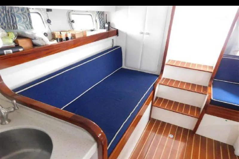 Slide: The Image of Interior of 1988 Magnum 40 Sport yacht with blue seating and wooden accents. - 21