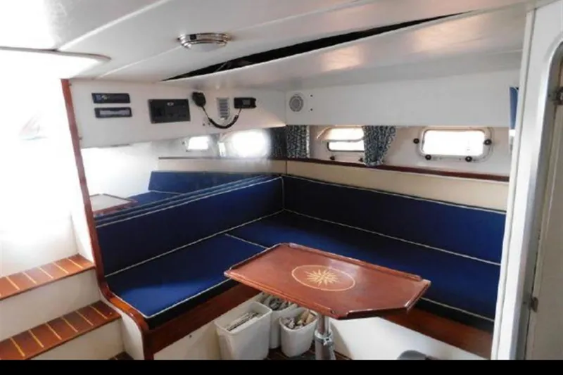 Slide: The Image of Interior of 1988 Magnum 40 Sport yacht with blue seating and wooden table. - 22